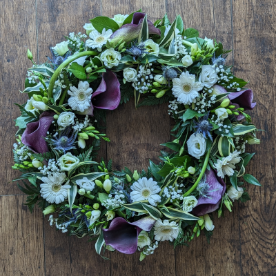 Opulent Funeral Wreath | A Beautiful and Meaningful floral tribute - A beautiful and meaningful way to remember a loved one who has passed away. Includes calla lilies, lisianthus, germini and thistle. Available in four sizes.